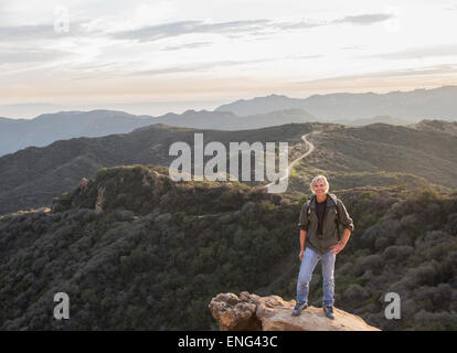 Caucasian homme debout sur une colline rocheuse Banque D'Images