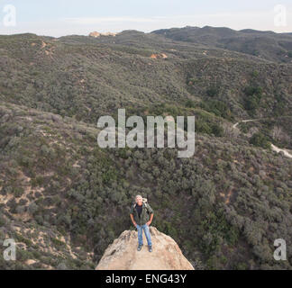 High angle view of Caucasian homme debout sur une colline rocheuse Banque D'Images