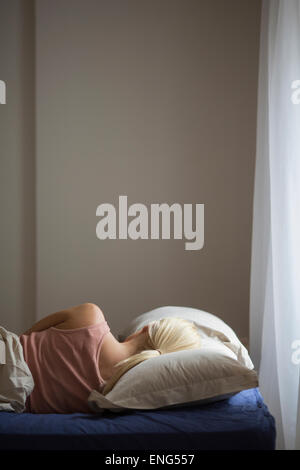 Rear view of woman sleeping in bed Banque D'Images