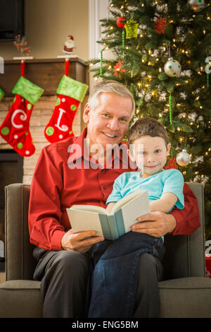 Grand-père en petit-fils lecture caucasienne à Noël Banque D'Images