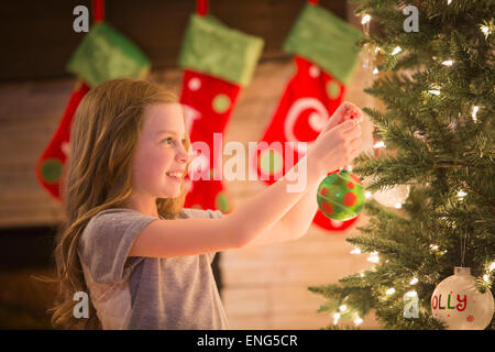 Caucasian girl decorating Christmas Tree Banque D'Images