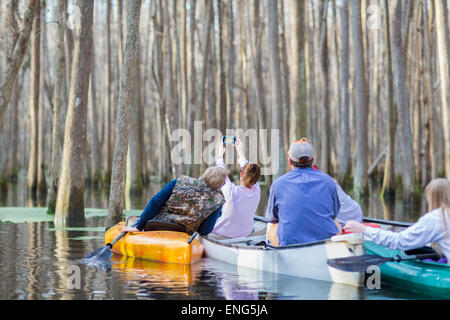 La famille caucasienne de prendre des photos de téléphone portable à bord de canots sur la rivière Banque D'Images