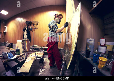 Artiste en masque à gaz à l'Aérosol peinture en studio Banque D'Images