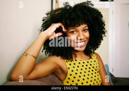 Mixed Race woman smiling on sofa Banque D'Images