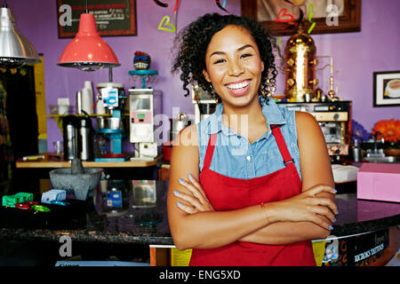 Mixed Race barista smiling in coffee shop Banque D'Images