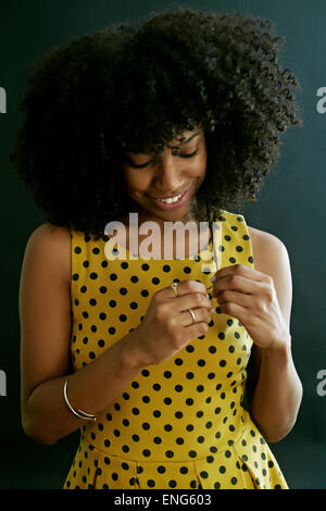 Close up of mixed race woman jouer avec ses cheveux bouclés Banque D'Images