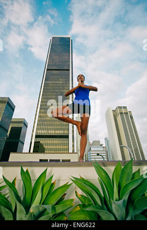 African American Woman practicing yoga on urban rooftop Banque D'Images