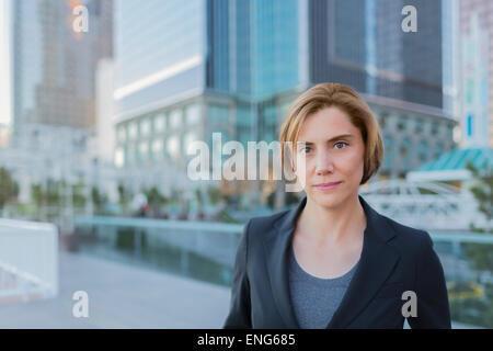 Caucasian businesswoman standing in city Banque D'Images