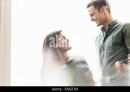 Un homme et femme qui parle dans un bureau autour d'un café. Banque D'Images