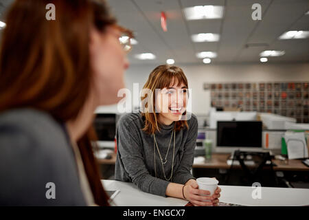 Deux femmes assises dans un bureau à parler. Banque D'Images