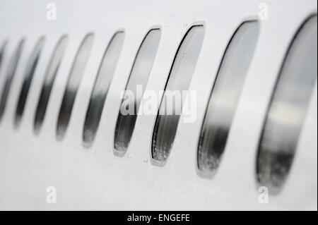 Les fenêtres de l'avion dans une rangée avec des gouttes de pluie sur eux Banque D'Images