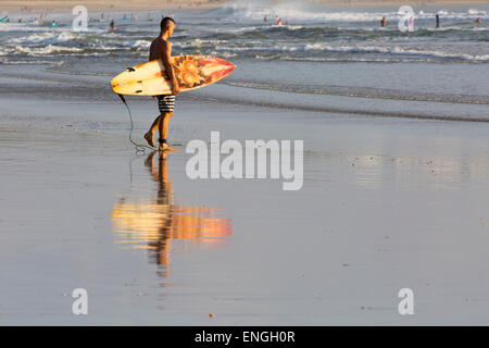 Surfer sur la plage de Kuta, Bali, Indonésie Banque D'Images