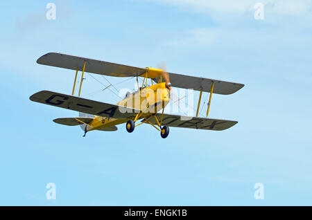 Un de Havilland DH.82 Tiger Moth monte biplan dans un ciel bleu après la prise de l'Aérodrome de PopHam Banque D'Images