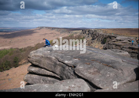 Un grimpeur prend un reste de Stanage Edge dans le Peak District Banque D'Images