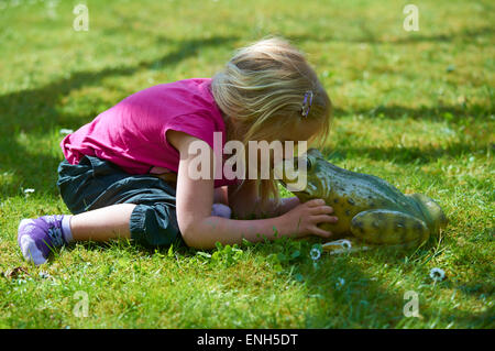 Petite blonde girl kissing Roi Grenouille enchantée Banque D'Images