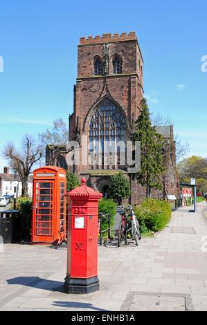 Vue sur l'église de l'abbaye de Saint Pierre et Saint Paul avec un vieux post box et téléphone fort au premier plan, Shrewsbury, Royaume-Uni. Banque D'Images