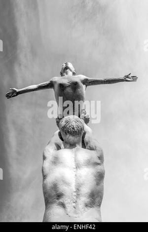 Les danseurs masculins et féminins en pierre contre un ciel bleu avec des nuages Banque D'Images