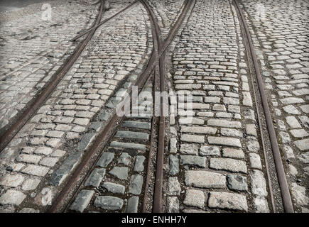 Vieilles lignes de chemin de fer sur la surface de la route pavée à un dock de Liverpool. Banque D'Images