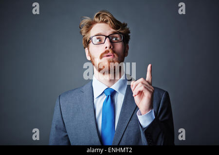 Homme d'affaires moderne avec maintien de barbe son index pointant vers le haut Banque D'Images