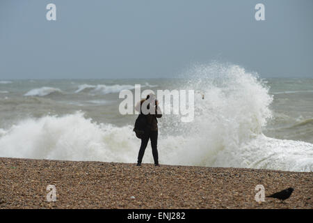 Une personne prend une photographie de l'grandes vagues, causés par une tempête, se briser sur la plage de Brighton, East Sussex, Angleterre. Banque D'Images