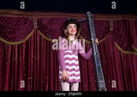 Girl Dress et combattre l'article Casque sur scène Holding de barils de shot gun appuyée debout sur scène avec cur rouge Banque D'Images