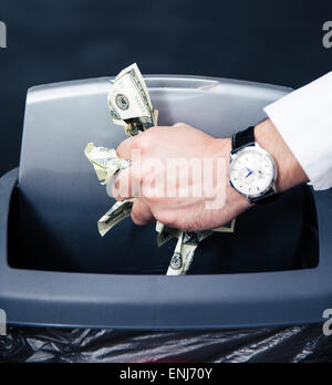 Notion de droit d'un homme d'affaires mains nous jeter des dollars dans la corbeille Banque D'Images