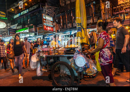 Les vendeurs de rue, les habitants et touristes se mêlent le long de la route Khao San dans la nuit. Bangkok. La Thaïlande. Banque D'Images