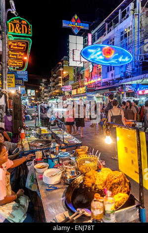 Les vendeurs de rue, les habitants et touristes se mêlent le long de la route Khao San dans la nuit. Bangkok. La Thaïlande. Banque D'Images