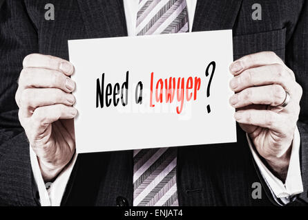 Un homme tenant une carte avec les mots, besoin d'un avocat, d'inscrit. Banque D'Images