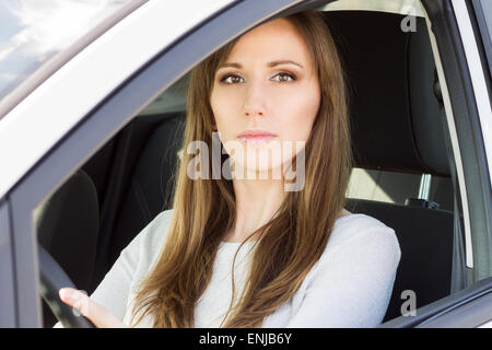 Jeune femme sérieuse en voiture. Portrait beauté fille adultes conduire une voiture Banque D'Images