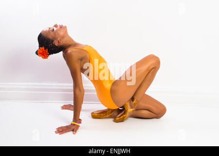 Femme africaine dans une ballerine danse moderne posent portant des gants orange Banque D'Images