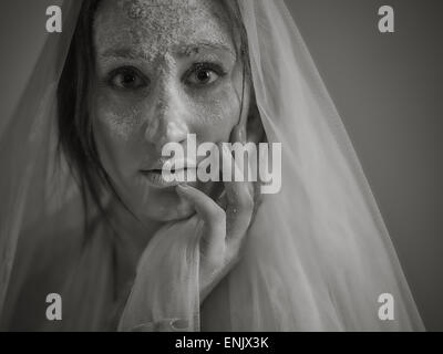Close up woman face et des cendres, elle vêtu de blanc toile, image en noir et blanc teinté, intentionnel bruit ajouté Banque D'Images