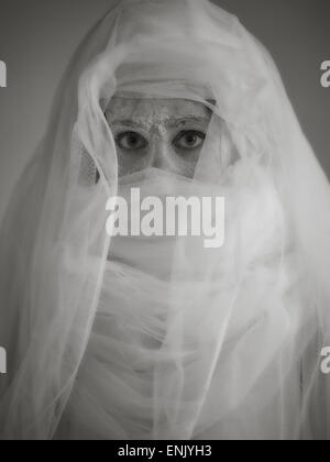 Fermer les yeux et de cendres, femme-elle porter toile blanche, image en noir et blanc teinté, intentionnel bruit ajouté Banque D'Images