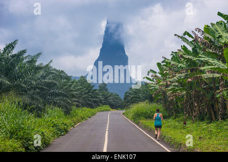 Runner sur une route menant à l'inhabituel, monolith Cao Pico Grande, côte est de Sao Tomé, Sao Tomé et Principe, de l'Océan Atlantique Banque D'Images