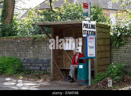 Un homme attend un bus dans un abri-bus en face du bureau de vote au Woodmancote Salle paroissiale. Photo par James Boardman Banque D'Images