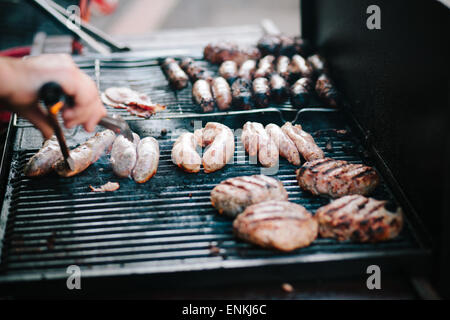 Des hamburgers et des saucisses barbecue'ed à Stroud farmers market, Stroud, Gloucestershire Banque D'Images