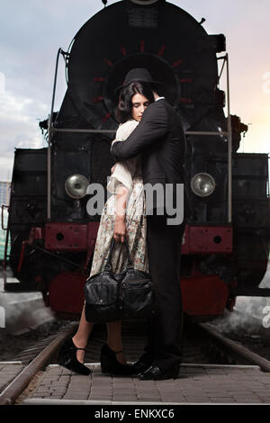 Quel beau couple de séparation sur fond de la locomotive à la gare Banque D'Images