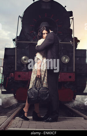 Quel beau couple de séparation sur fond de la locomotive à la gare Banque D'Images