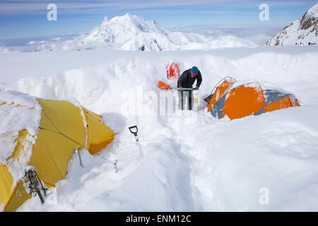 Une montagne Ranger est creuser hors tentes après une tempête les a couverts pendant la nuit dans le camp de 14k sur le mont McKinley, en Alaska. Banque D'Images