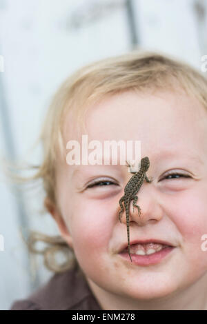 Bébé fille sourit à huis clos, avec l'armoise lizard on nez à Chico, Californie. Banque D'Images