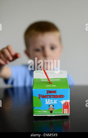 Un petit garçon avec son lait dans les écoles. Photo : Scott Bairstow/Alamy Banque D'Images