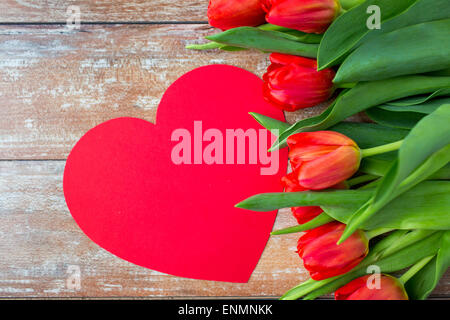 Close up de tulipes rouges et de papier carte en forme de coeur Banque D'Images