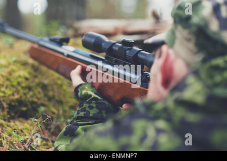 Soldat ou hunter tir avec arme à feu en forêt Banque D'Images