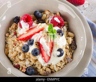 Petit-déjeuner sain - Les baies fraîches, de yaourts et de muesli. Selective focus Banque D'Images