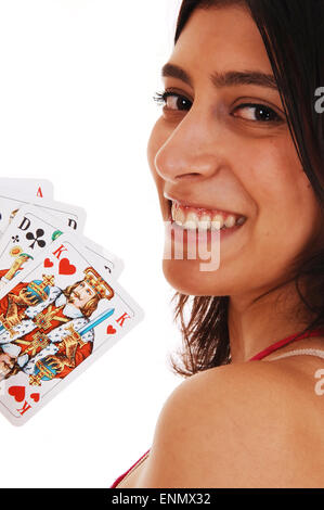 A smiling young woman holding up gros plan dans un jeu de cartes, isolé sur fond blanc. Banque D'Images