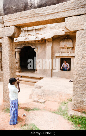 Les touristes posant dans une ancienne cave Temple, Mamallapuram. Banque D'Images