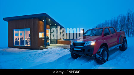 Le sur mesure 4x4 pick up truck garé à l'extérieur d'un chalet en hiver dans le nord de l'Islande à Laugar, pendant une tempête Banque D'Images