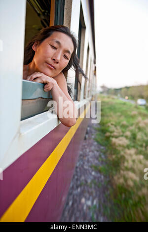 Woman leaning out de la fenêtre du train à Chiang Mai dans le nord de la Thaïlande Banque D'Images