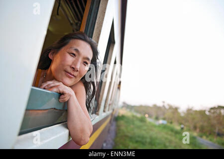 Woman leaning out de la fenêtre du train à Chiang Mai dans le nord de la Thaïlande Banque D'Images