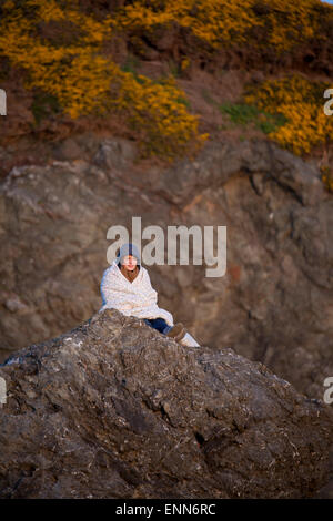 Une jeune femme composée sur un rocher promontoire de Bandon Bay, Oregon. Banque D'Images